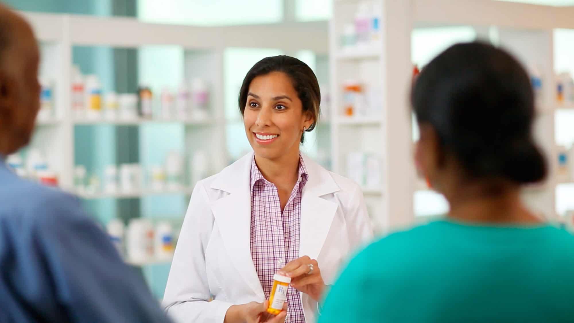 Pharmacist provides prescription explanation to a couple at a Baltimore Medical System pharmacy.